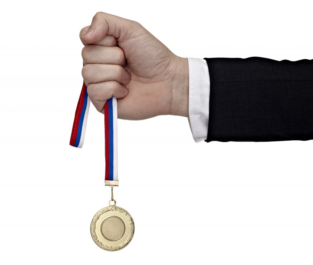 business hand holding golden medal